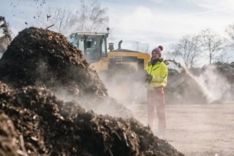 Arrosage d'un andain de compost au chargeur sur le site d'EXTRAM